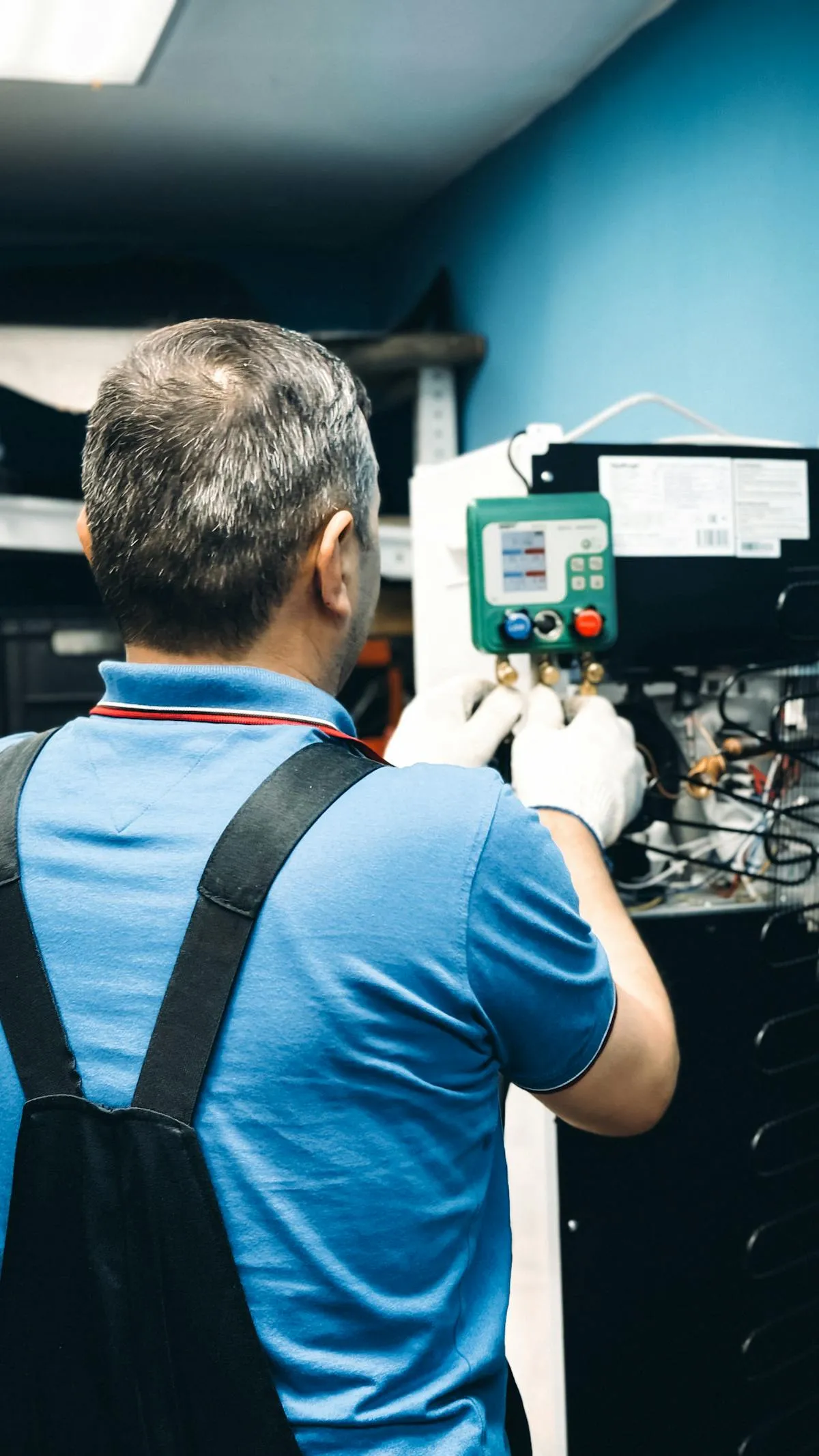 Technician checking refrigerant pressures with manifold gauges